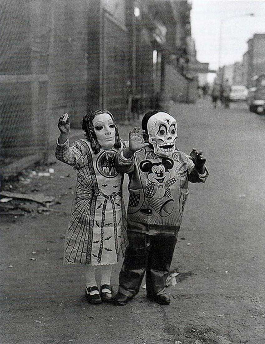 Aterradores disfraces de halloween del pasado. Dos niños con vestidos de disney pero con máscaras macabras.