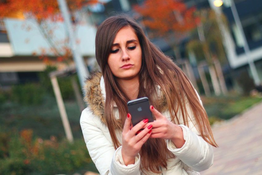 Mujer observando su teléfono móvil. por qué amigos hacen ghosting