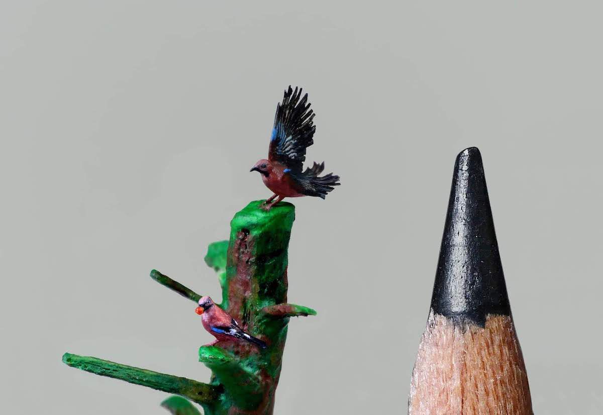 Esculturas mircroscópicas. Marie Cohydon. Dos pájaros, uno con una fruta en el pico y otro extiende sus alas.