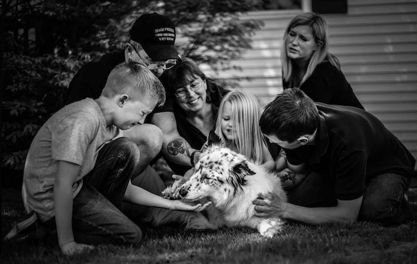 Una familia contempla a su perro. Un niño está llorando.