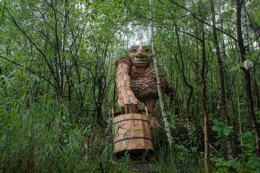 Esculturas de Thomas Dambo gigantes. Troll caminando en el bosque con una vasija