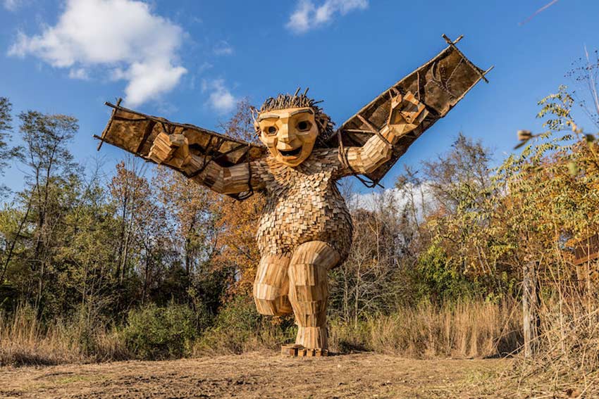 Esculturas de Thomas Dambo gigantes. Troll en corriendo con alas en sus brazos 2