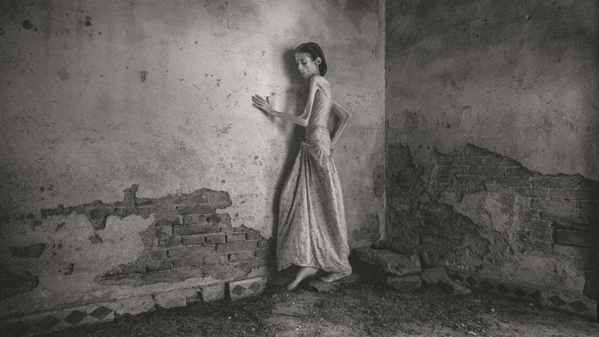 Autorretrato Lene Marie Fossen. En la foto una mujer que sufre anorexia recostada en una pared de un cuarto.