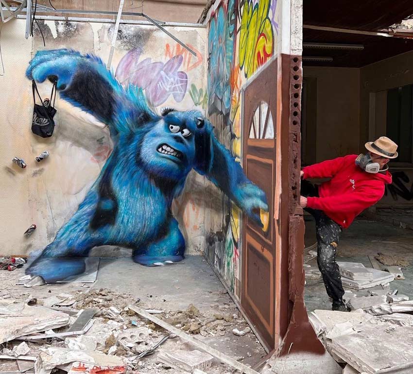 El personaje Sulley de Monster inc pintado en un muro, está sosteniendo una puerta.