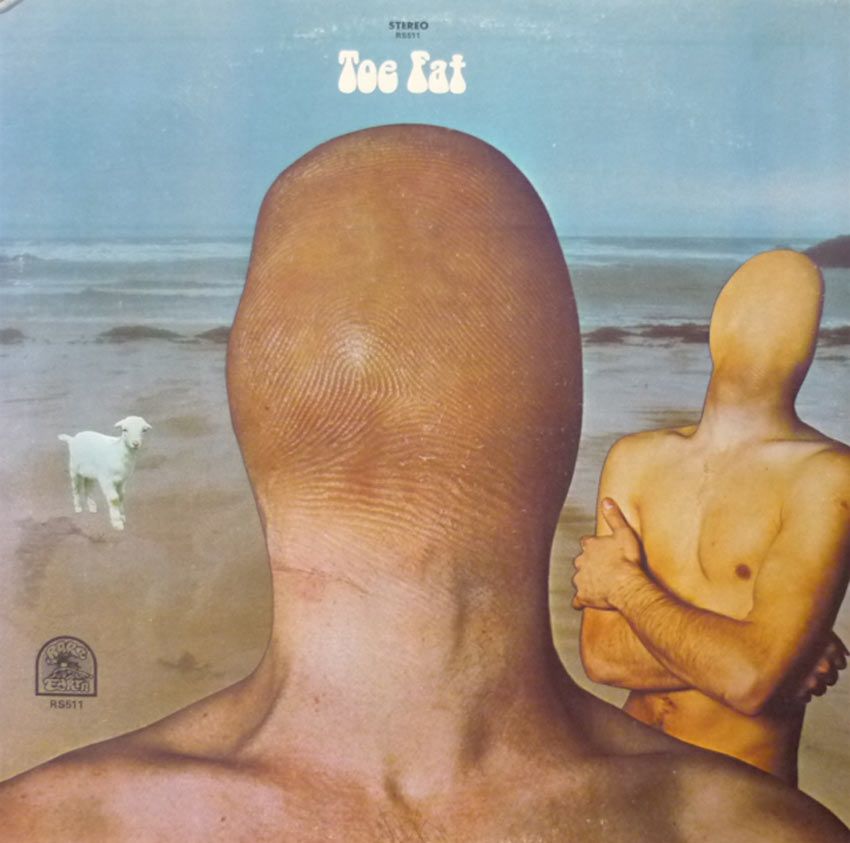 En la imagen, dos personas con cabeza con forma de dedo en una playa. También hay una oveja. Al fondo el mar abierto